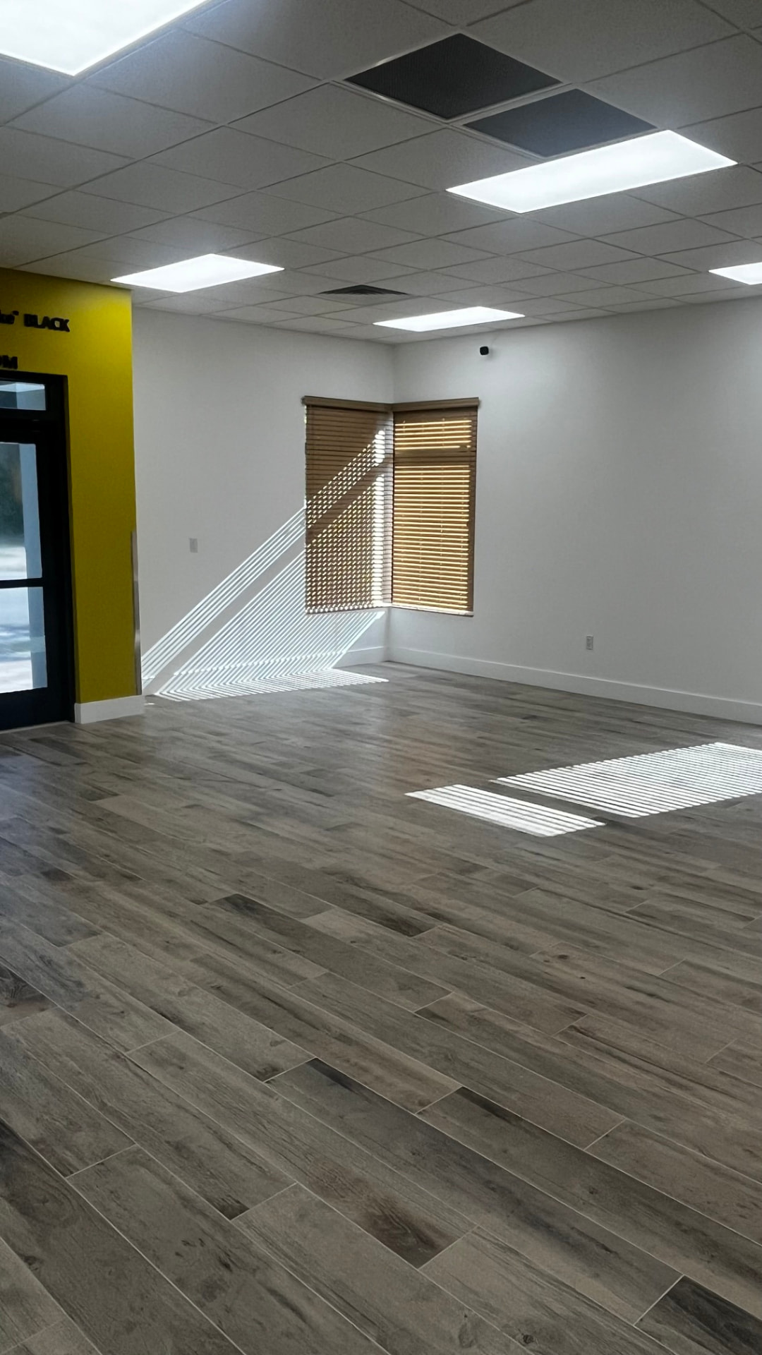 Event room empty — yellow accent wall with natural light through the windows
