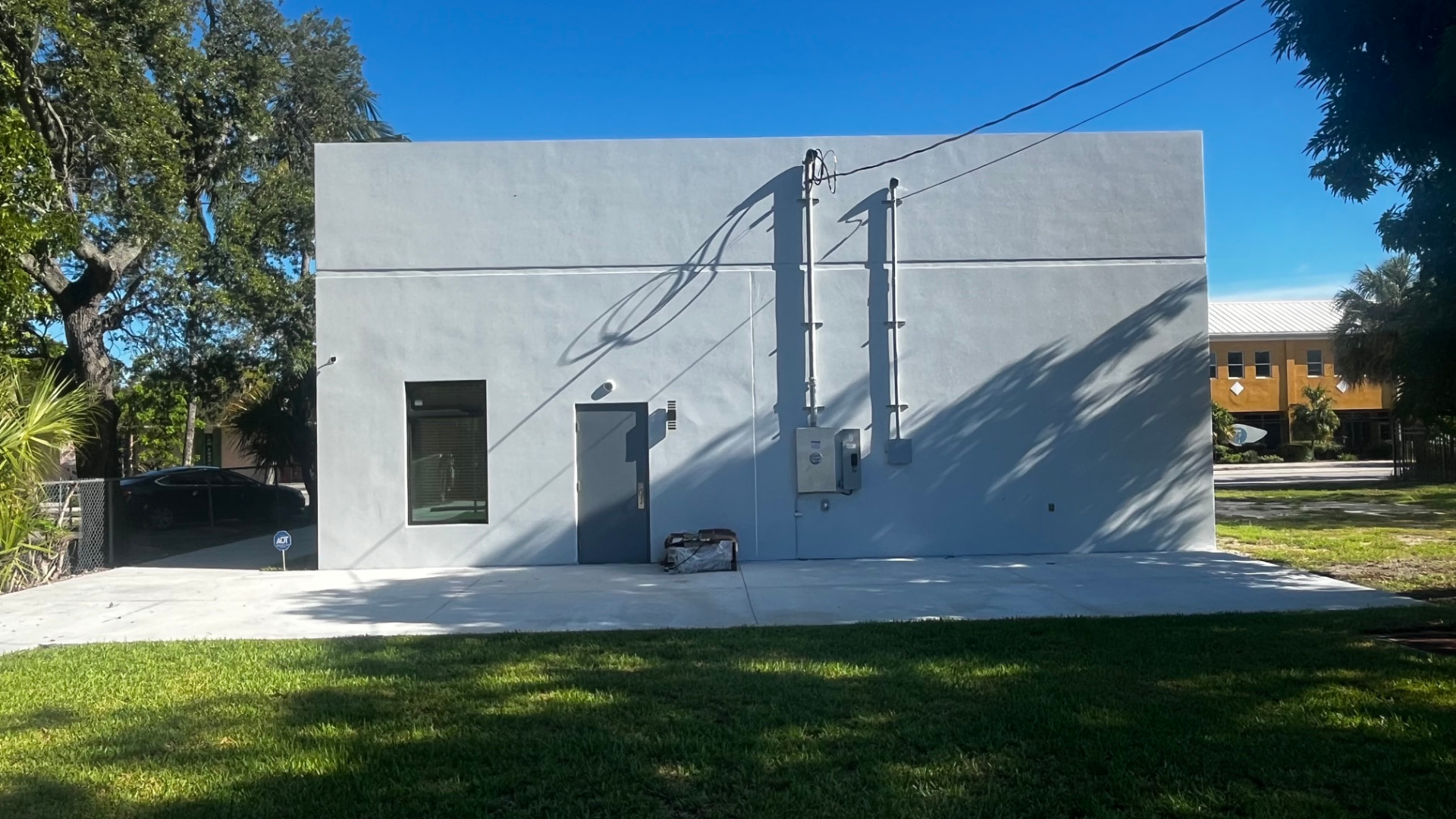 Side of the building with lawn and parking area